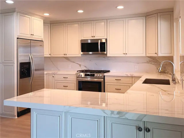 a kitchen with stainless steel appliances granite countertop a sink a stove a microwave and island