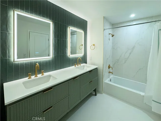 a bathroom with a double vanity sink mirror double and a bathtub