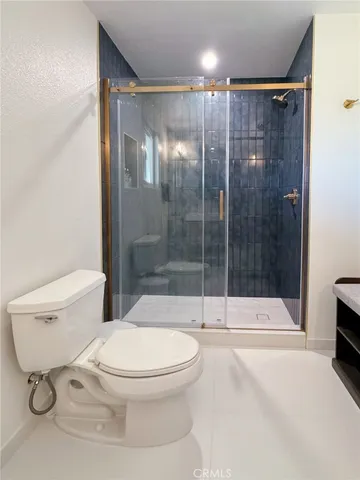 a bathroom with a toilet and a shower