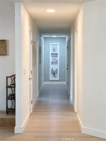 a view of a hallway with wooden shelves