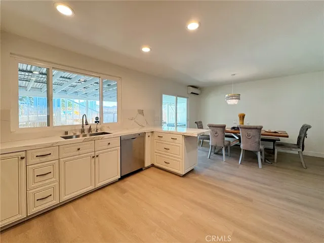 a large white kitchen with white cabinets and wooden floor
