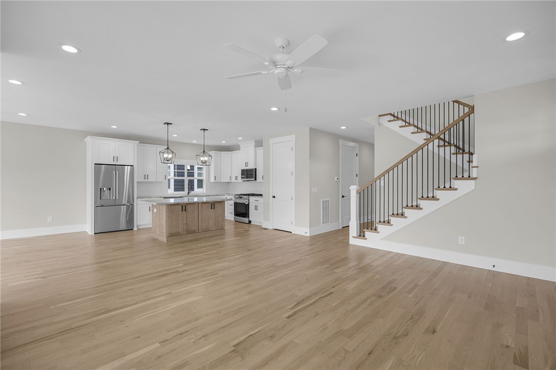 1230 Melton Road, Unit 216 West Union, SC 29696 - Photo 11 of 49 Blonde hardwood flooring connects an open-concept kitchen with a modern staircase.