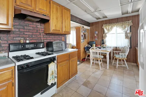 a kitchen with a stove a sink a table and chairs