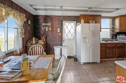 a bedroom with furniture a window and a refrigerator