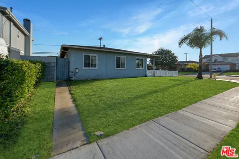 a front view of a house with garden and parking