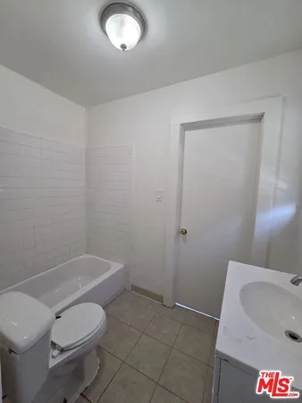 a white toilet sitting next to a bath tub