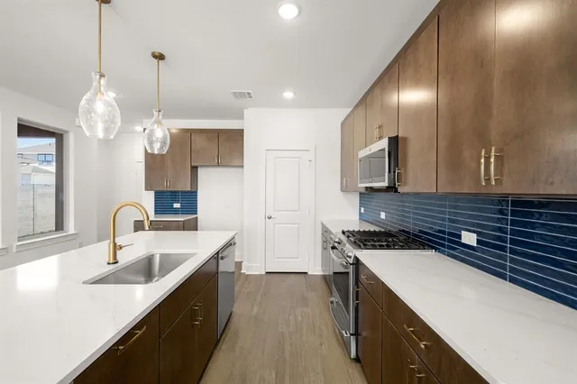 a view of kitchen with wooden floor and electronic appliances