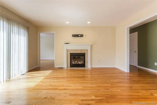 a view of an empty room with window and fire place