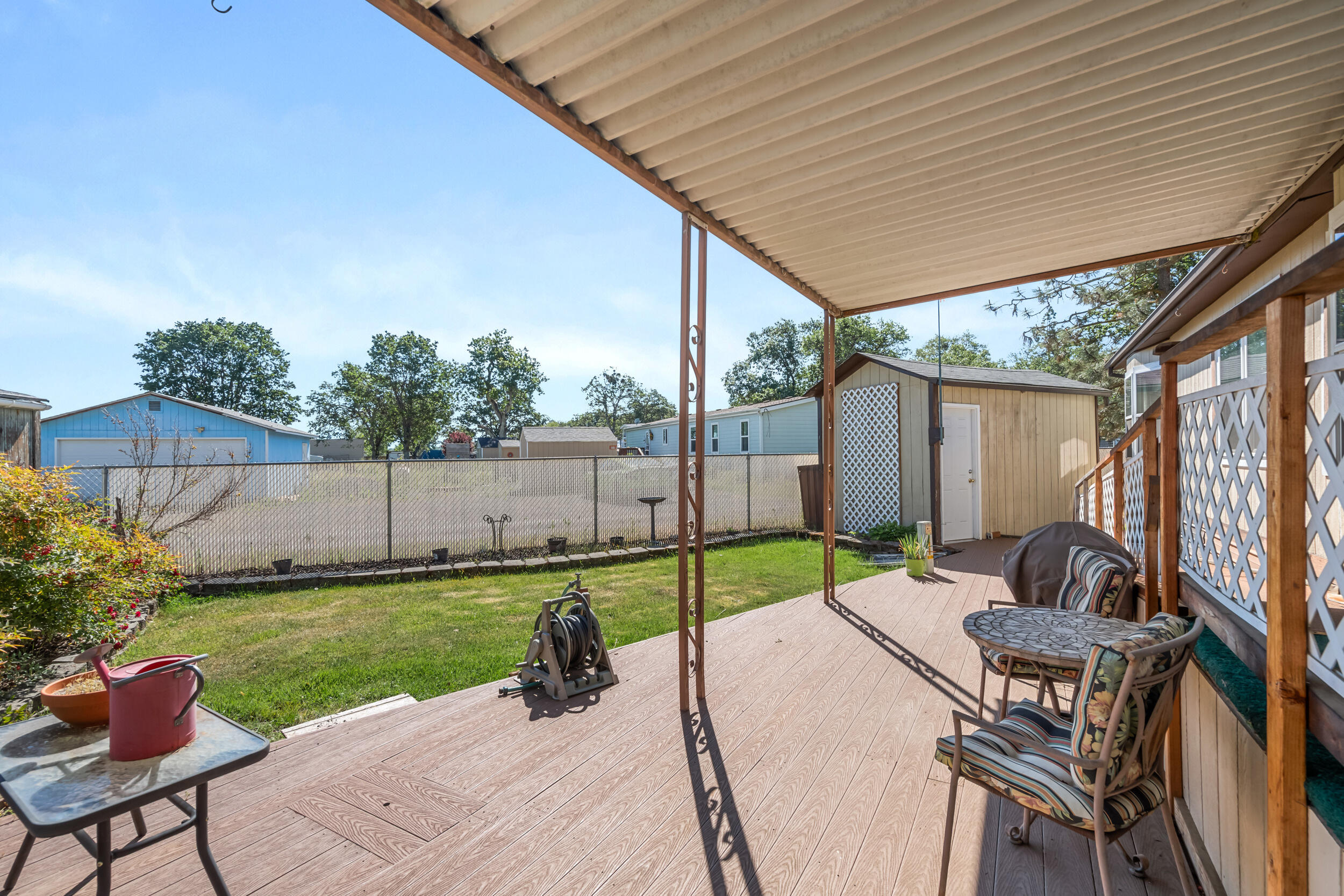 6850 Downing Road, Unit SPC 24 Central Point, OR 97502 - Photo 18 of 26 a view of a backyard with table and chairs under an umbrella