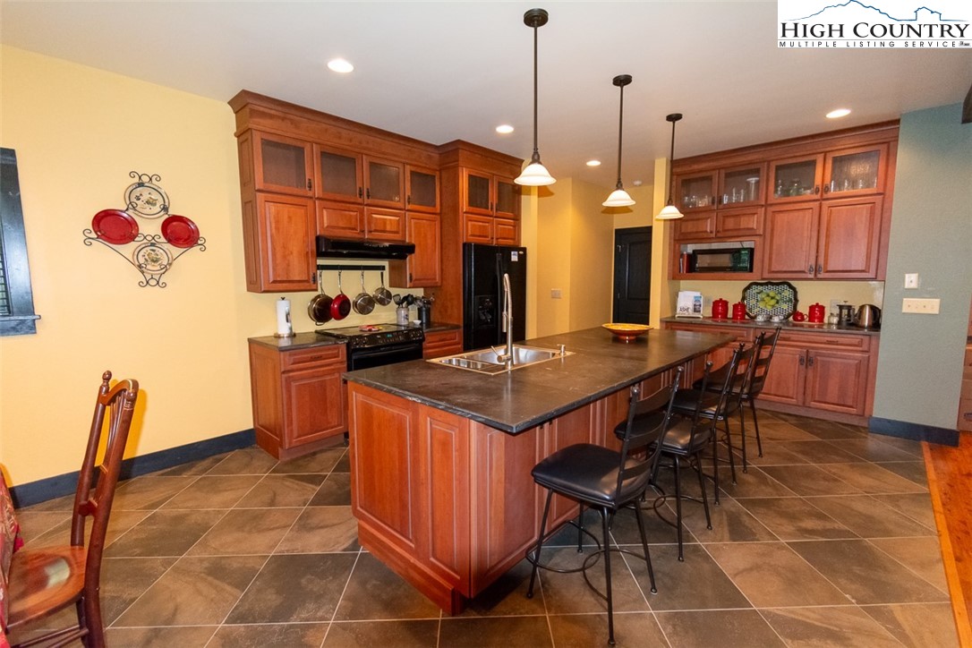 572 Stonegate Lane Creston, NC 28615 - Photo 15 of 48 a kitchen with stainless steel appliances granite countertop a sink a stove and a wooden floors