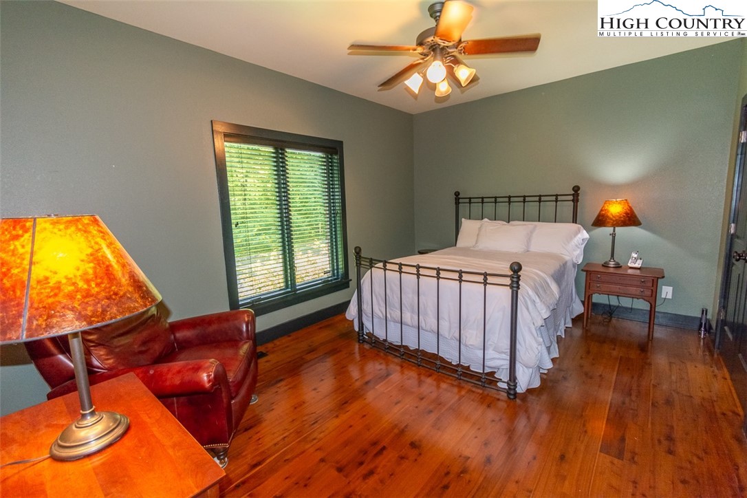 572 Stonegate Lane Creston, NC 28615 - Photo 24 of 48 a bedroom with a bed and wooden floor