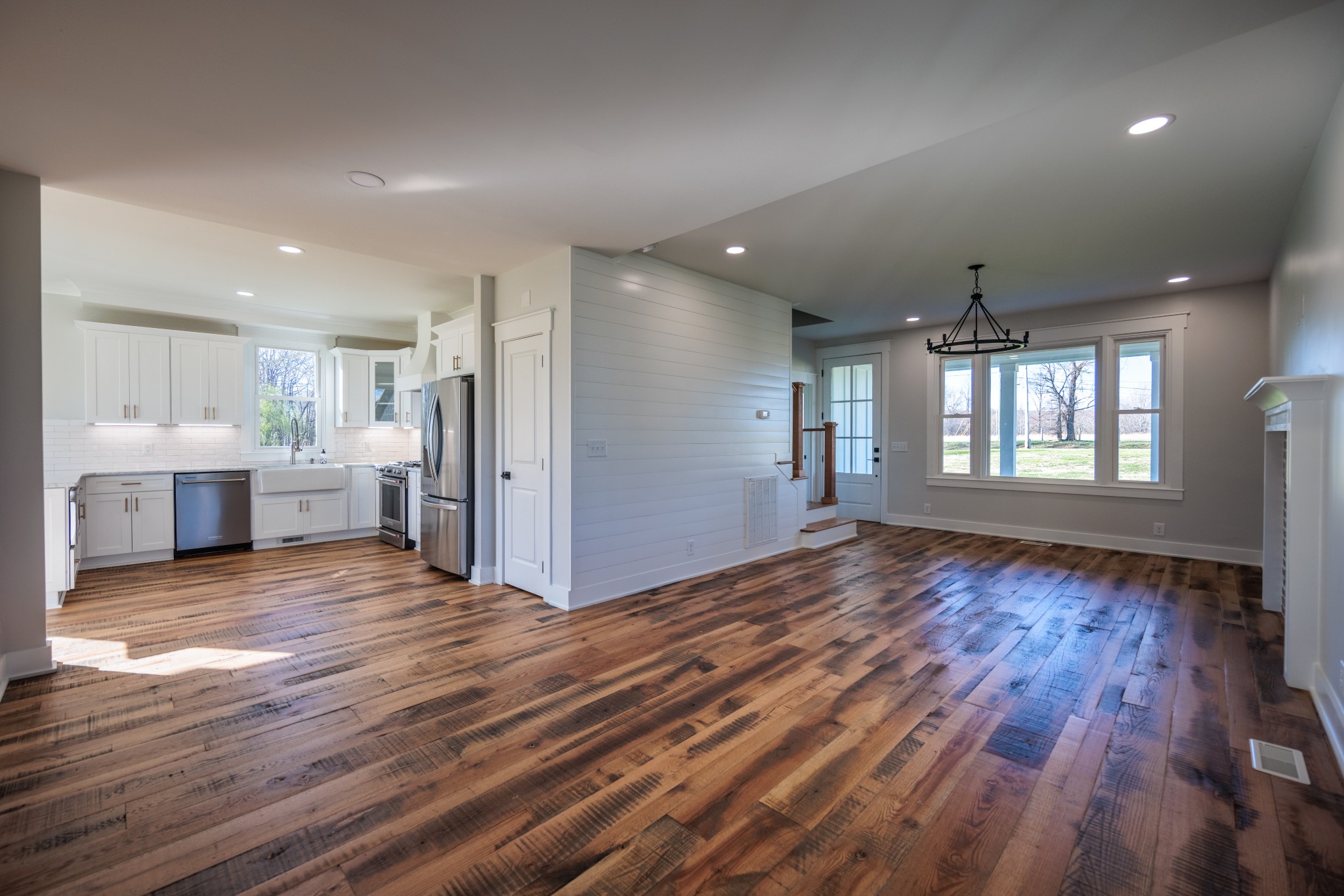 7776 Lampley Road Primm Springs, TN 38476 - Photo 20 of 50 a view of an empty room with wooden floor and a kitchen