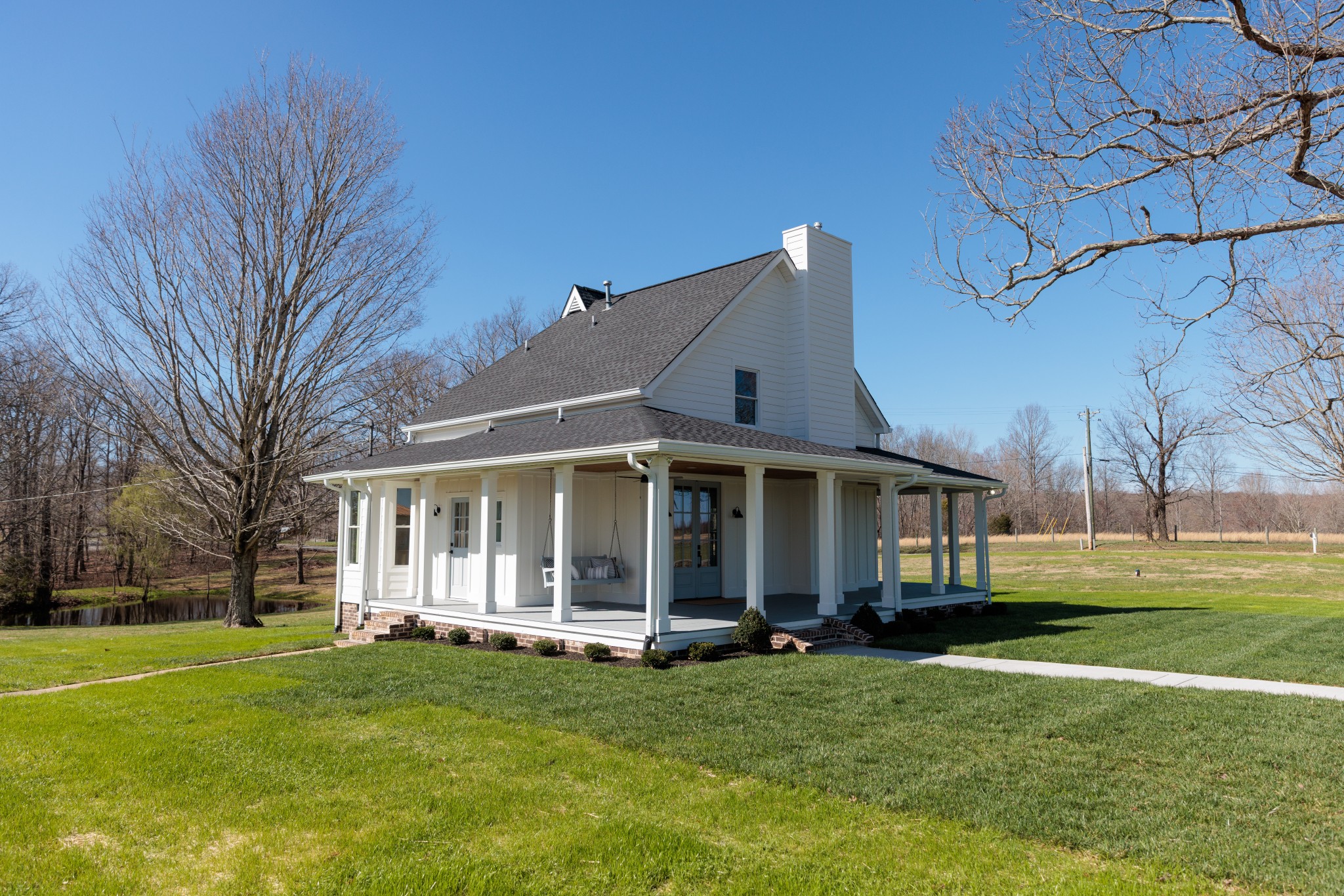 7776 Lampley Road Primm Springs, TN 38476 - Photo 3 of 50 a view of a white house with a big yard and large trees