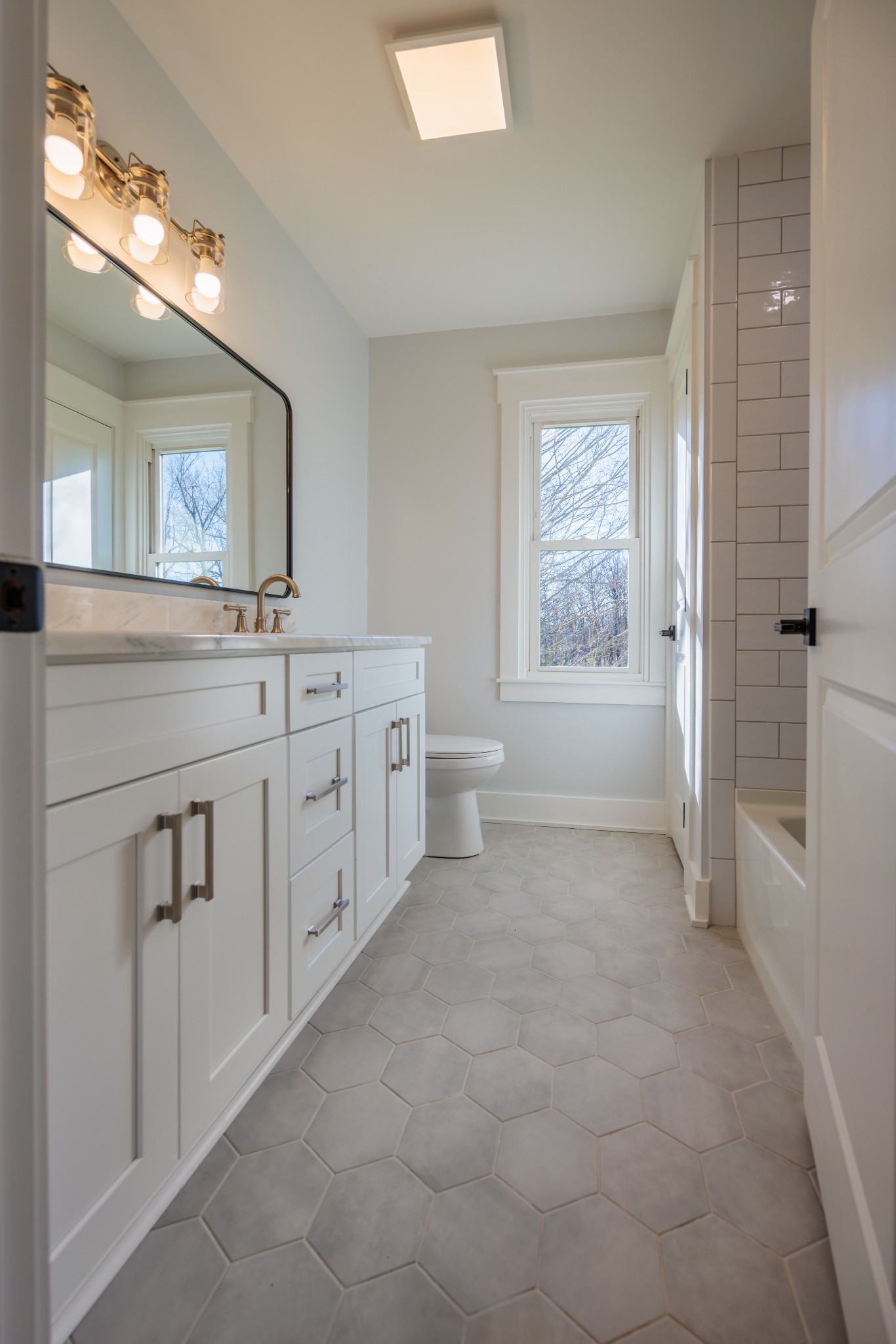 7776 Lampley Road Primm Springs, TN 38476 - Photo 36 of 50 a spacious bathroom with a granite countertop sink a toilet and a mirror