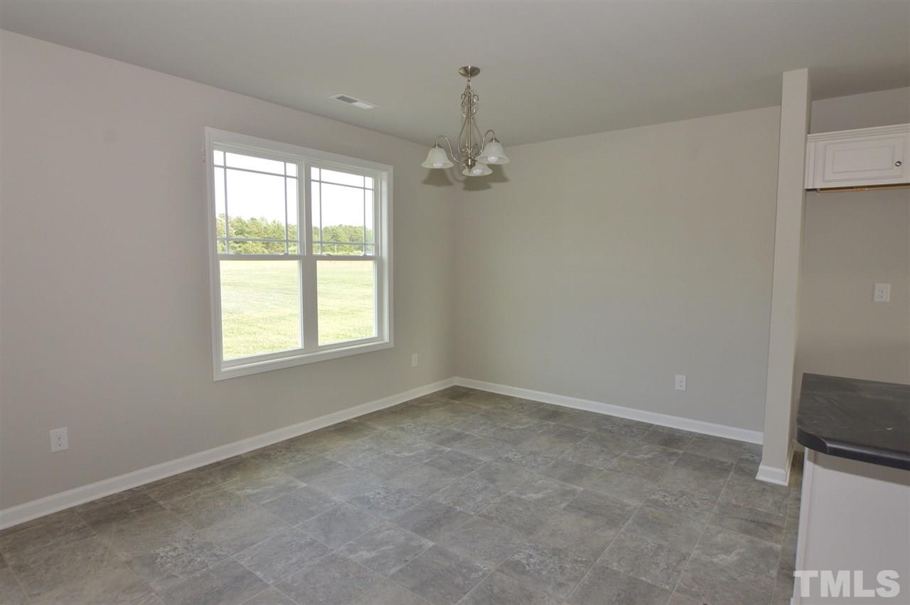 92 Willow Ridge Circle Willow Spring, NC 27592 - Photo 9 of 16 an empty room with windows and chandelier fan