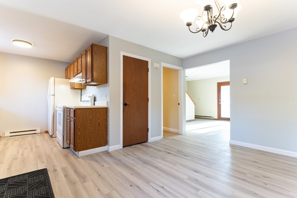 38 Drake Road, Unit 38 Fitchburg, MA 01420 - Photo 8 of 31 a view of a kitchen with a refrigerator a ceiling fan and wooden floor