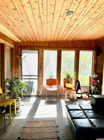 a living room with furniture fireplace and large windows