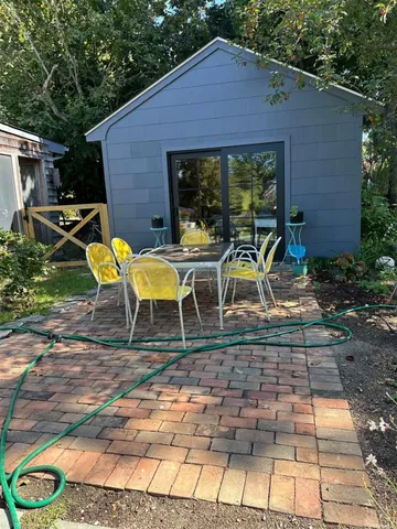 a view of a house with backyard sitting area and garden
