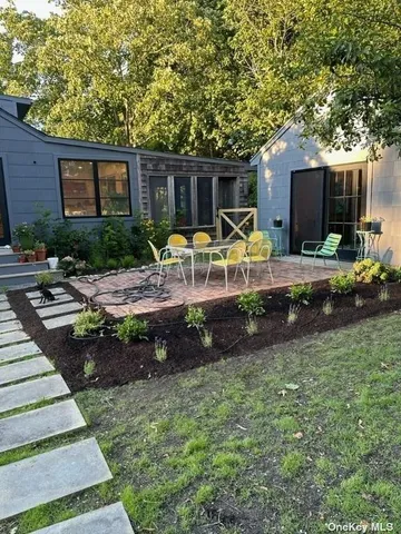 a view of a house with backyard and sitting area