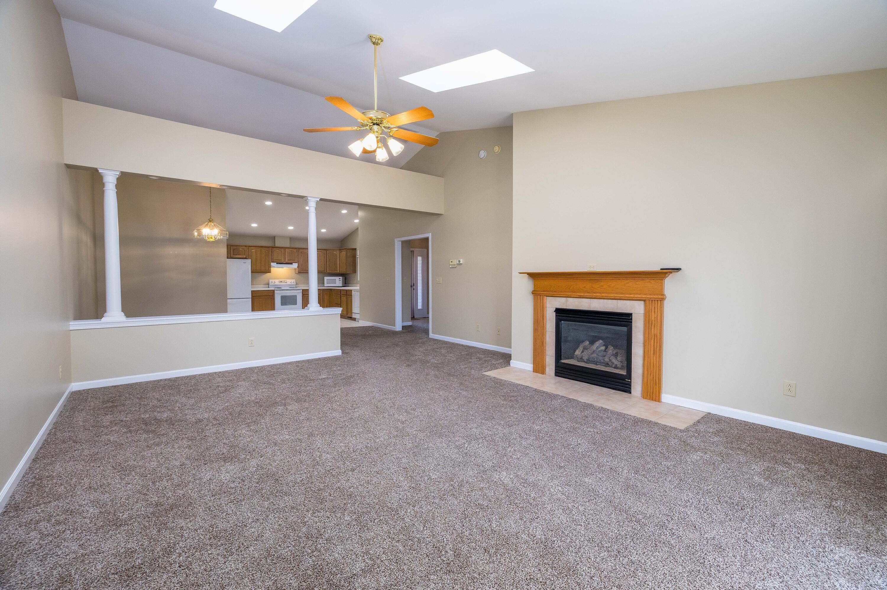 431 Pheasant Run Rensselaer, IN 47978 - Photo 14 of 31 an empty room with a fireplace and chandelier