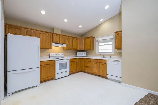 a kitchen with granite countertop stainless steel appliances refrigerator cabinets and a sink