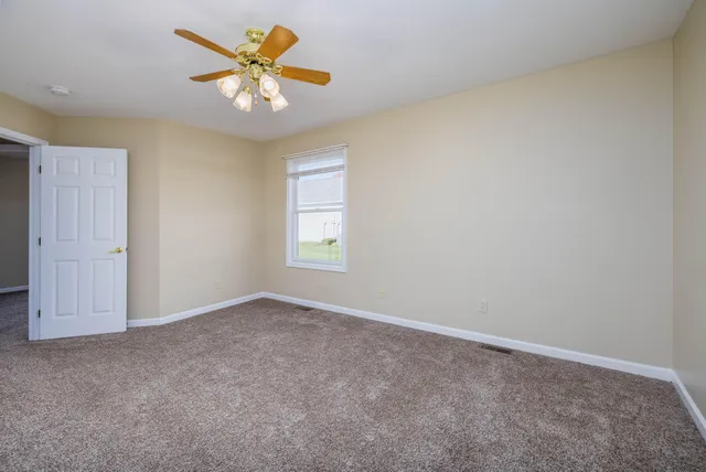 an empty room with closet and a chandelier fan