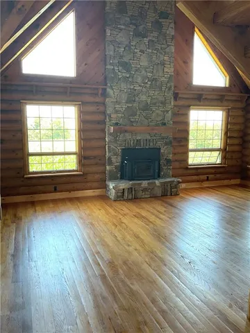 a view of an empty room with exposed radiator and fireplace