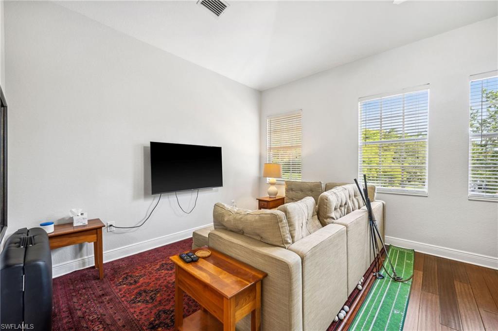 7859 Hawthorne Terrace, Unit 1504 Naples, FL 34113 - Photo 21 of 43 a living room with furniture and a flat screen tv