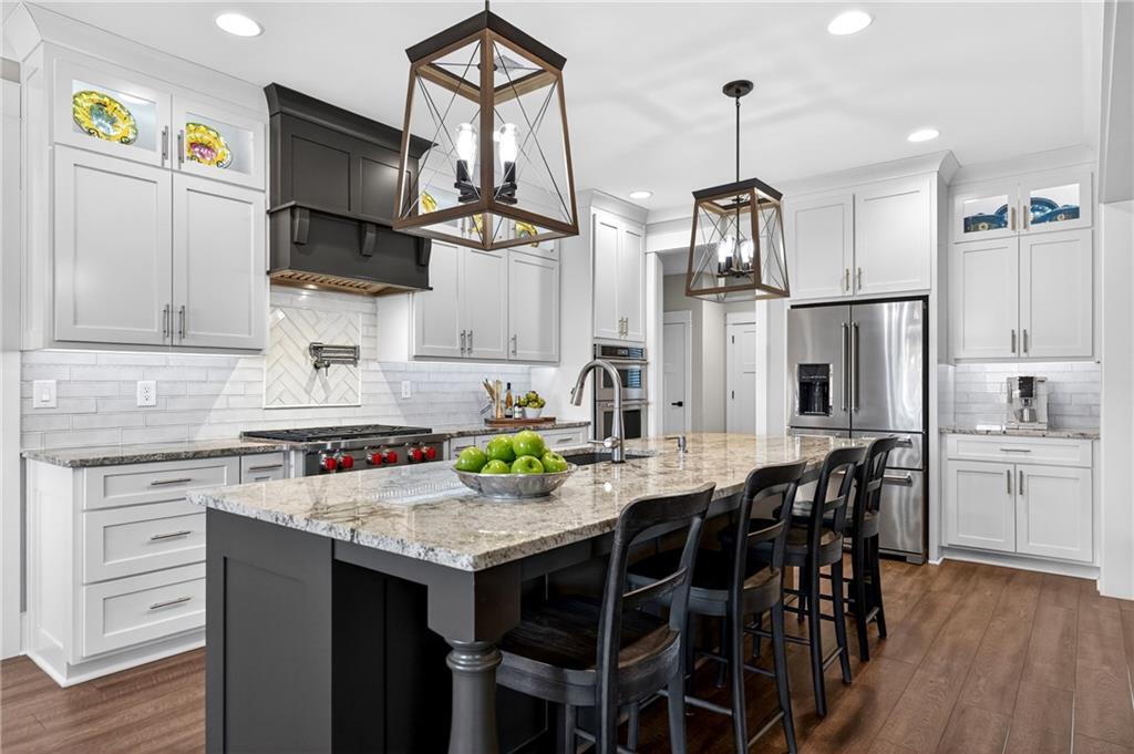 353 Newt Green Road Ball Ground, GA 30107 - Photo 12 of 52 a kitchen with stainless steel appliances a dining table chairs stove refrigerator and microwave