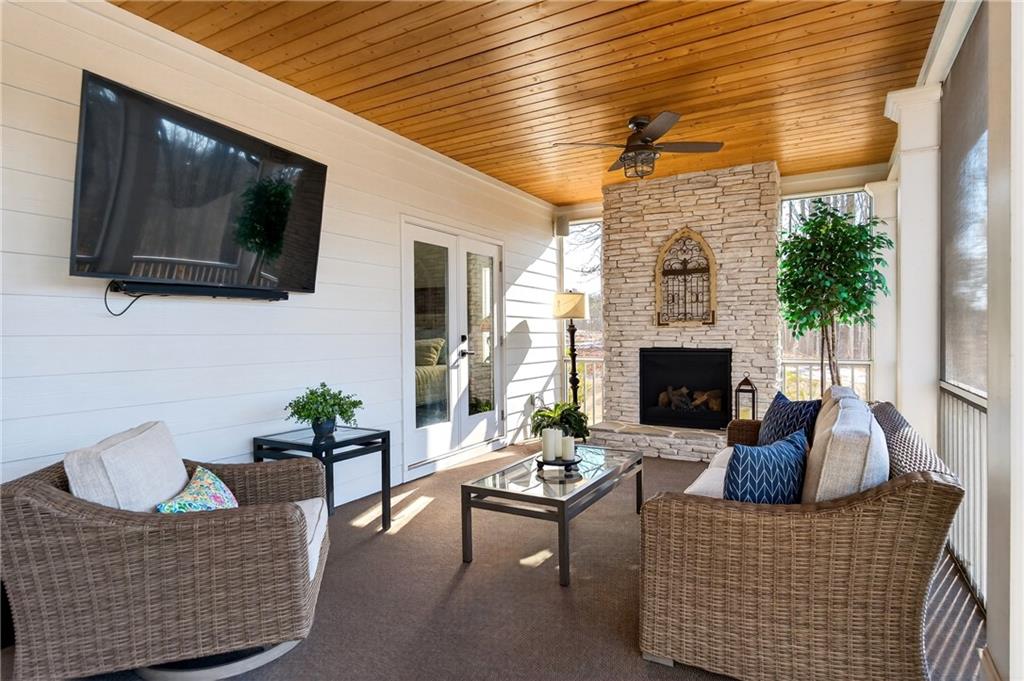 353 Newt Green Road Ball Ground, GA 30107 - Photo 17 of 52 a living room with furniture a flat screen tv and a fireplace
