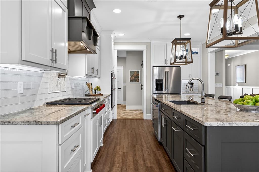 353 Newt Green Road Ball Ground, GA 30107 - Photo 19 of 52 a kitchen with stainless steel appliances granite countertop a stove and a sink