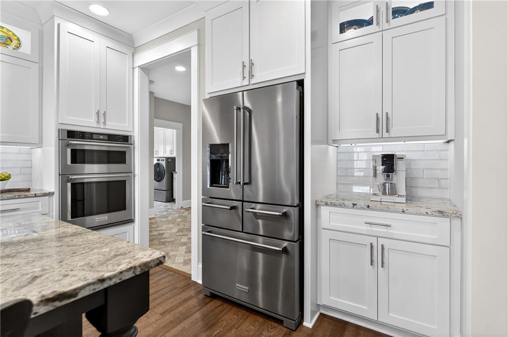 353 Newt Green Road Ball Ground, GA 30107 - Photo 21 of 52 a kitchen with stainless steel appliances white cabinets and wooden floor