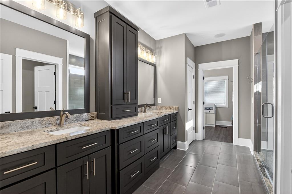 353 Newt Green Road Ball Ground, GA 30107 - Photo 25 of 52 a spacious bathroom with a granite countertop sink mirror and a