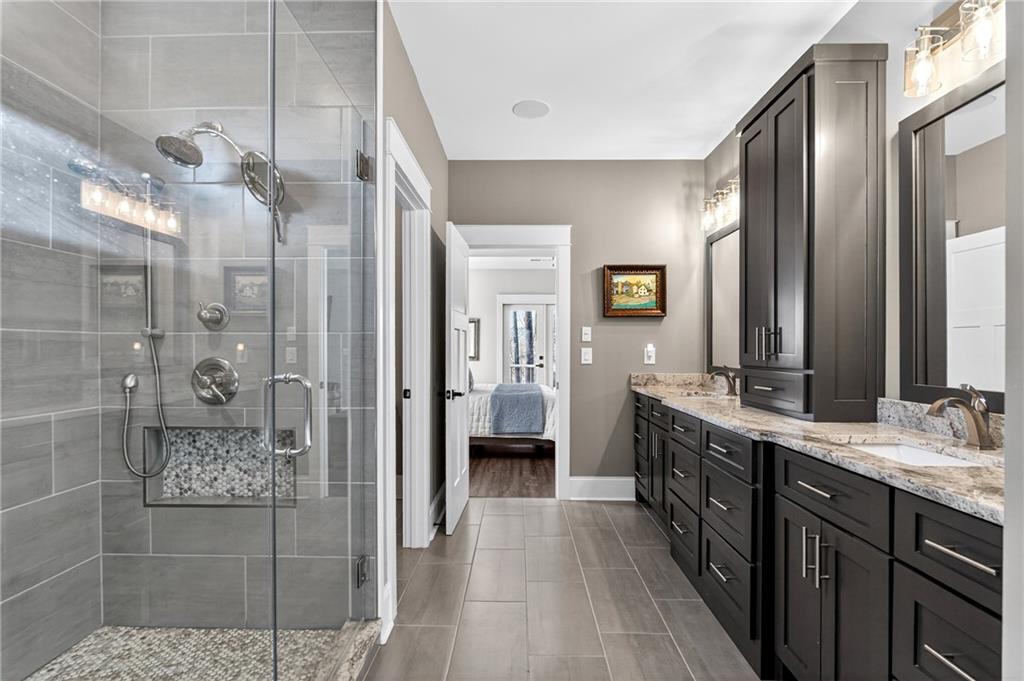 353 Newt Green Road Ball Ground, GA 30107 - Photo 27 of 52 a bathroom with a double vanity sink and mirror