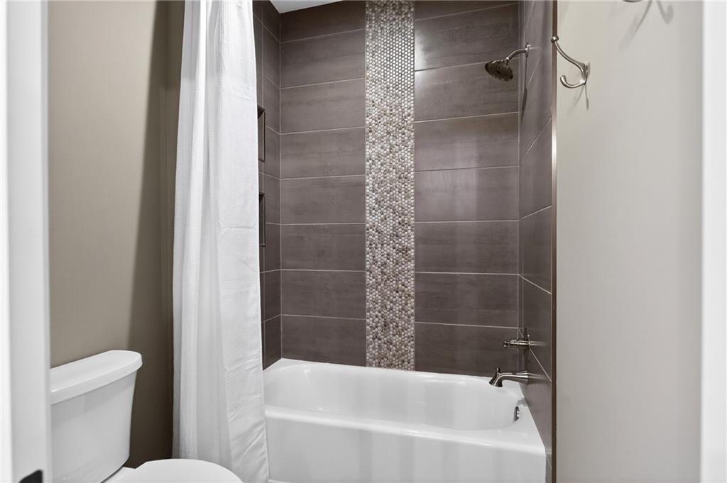 353 Newt Green Road Ball Ground, GA 30107 - Photo 30 of 52 a bathroom with a bathtub and a shower