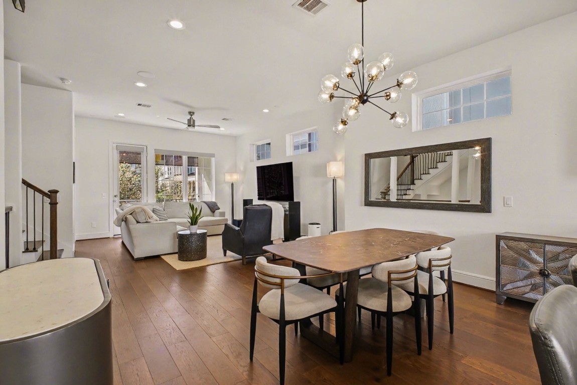 3507 Ridgeway Valley Lane Houston, TX 77055 - Photo 5 of 50 This open-concept living and dining area features modern lighting, hardwood floors, and a neutral color palette. The space includes a comfortable seating area with natural light from large windows and a stylish dining table set, creating an inviting atmosphere for both relaxation and entertaining.