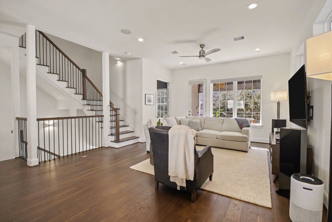 3507 Ridgeway Valley Lane Houston, TX 77055 - Photo 10 of 50 This inviting living room features hardwood floors, a cozy seating area, and a modern ceiling fan. Large windows offer ample natural light, and the open staircase adds a stylish touch.