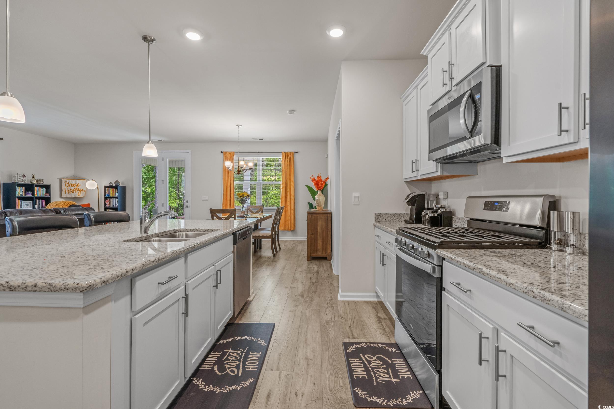 847 Flowering Br Avenue Little River, SC 29566 - Photo 30 of 30 Kitchen featuring stainless steel appliances, white cabinetry, open floor plan, light wood finished floors, and recessed lighting
