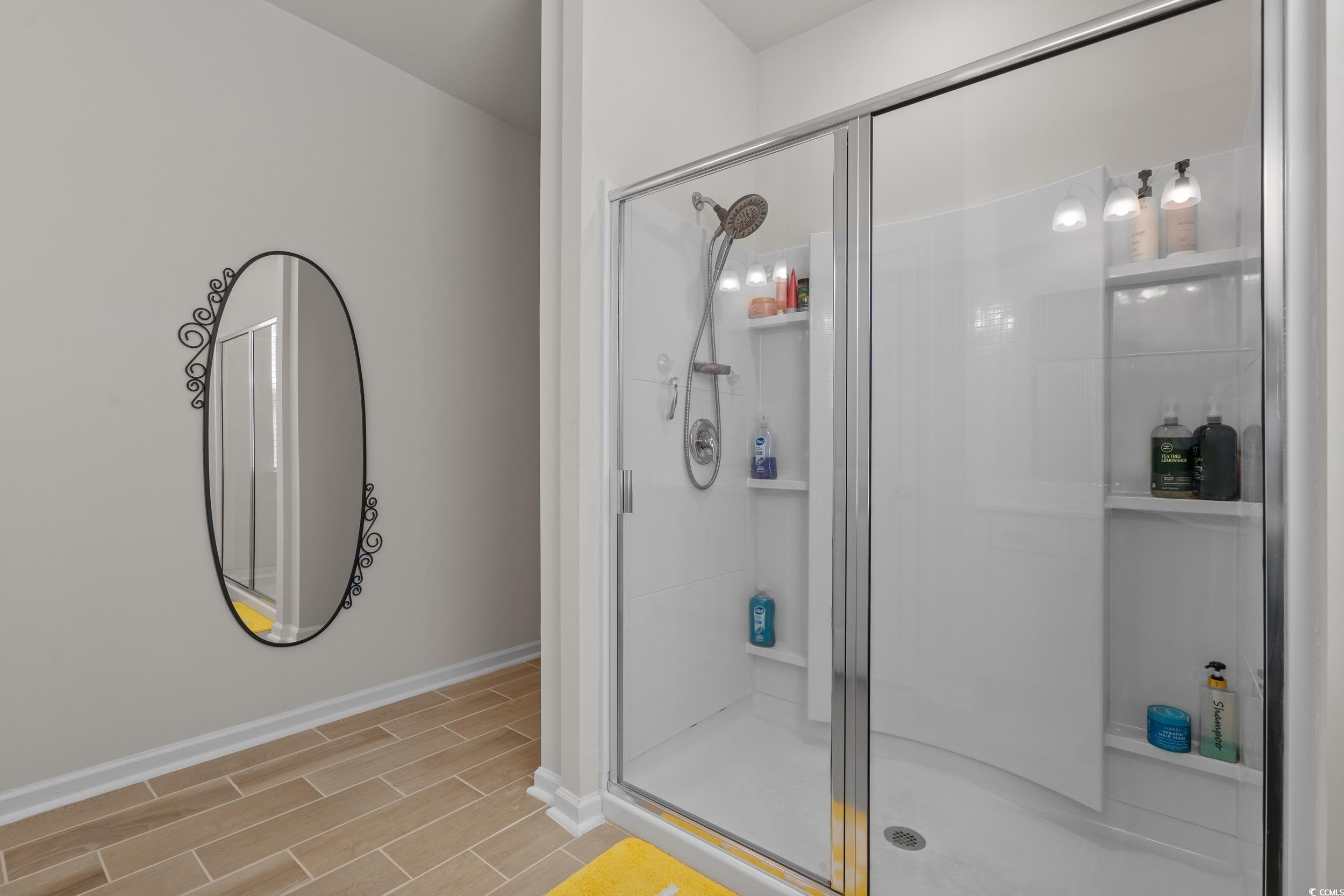 847 Flowering Br Avenue Little River, SC 29566 - Photo 17 of 30 Full bath featuring a stall shower and wood finish floors