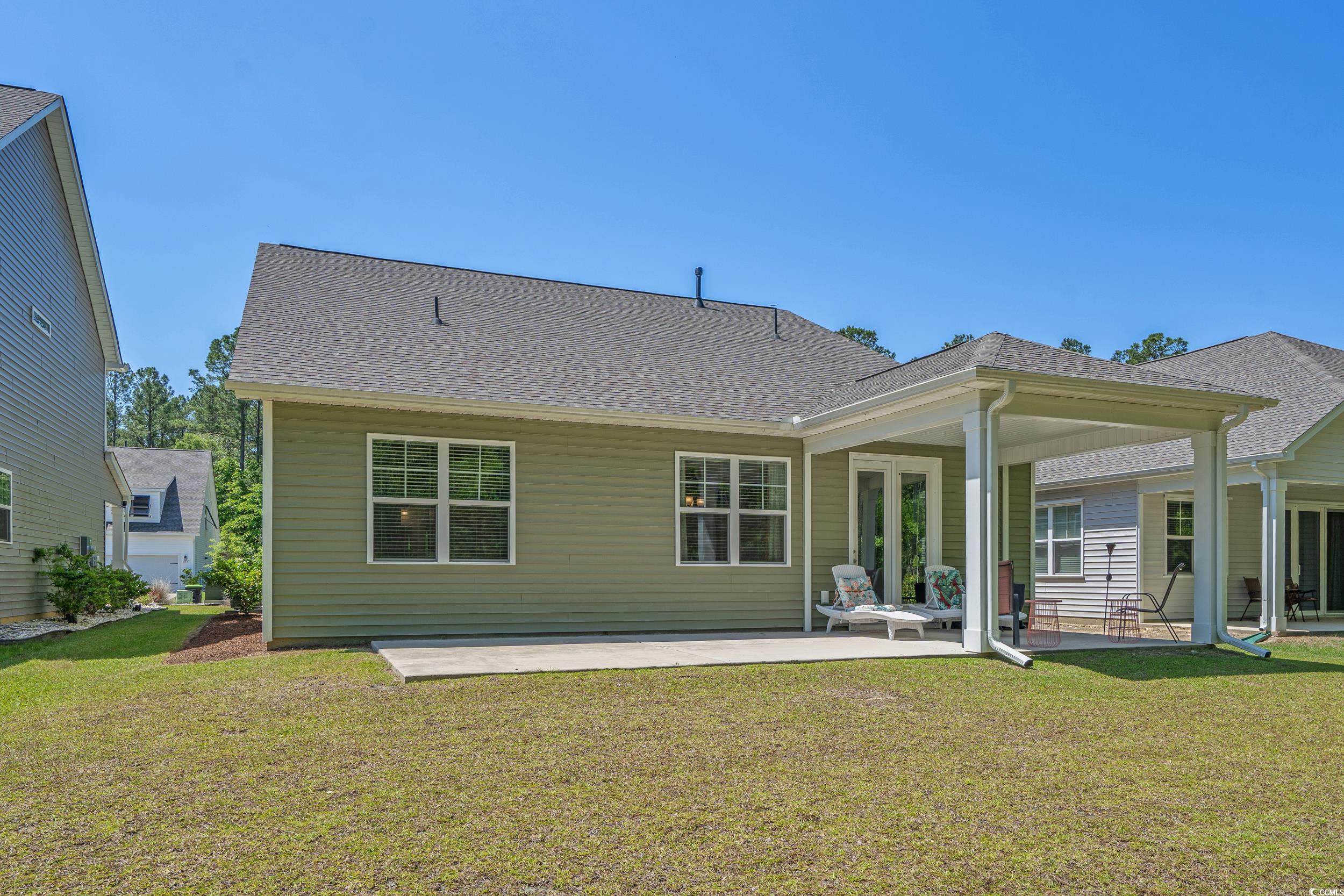 847 Flowering Br Avenue Little River, SC 29566 - Photo 18 of 30 Rear view of house featuring a patio, roof with shingles, and a lawn