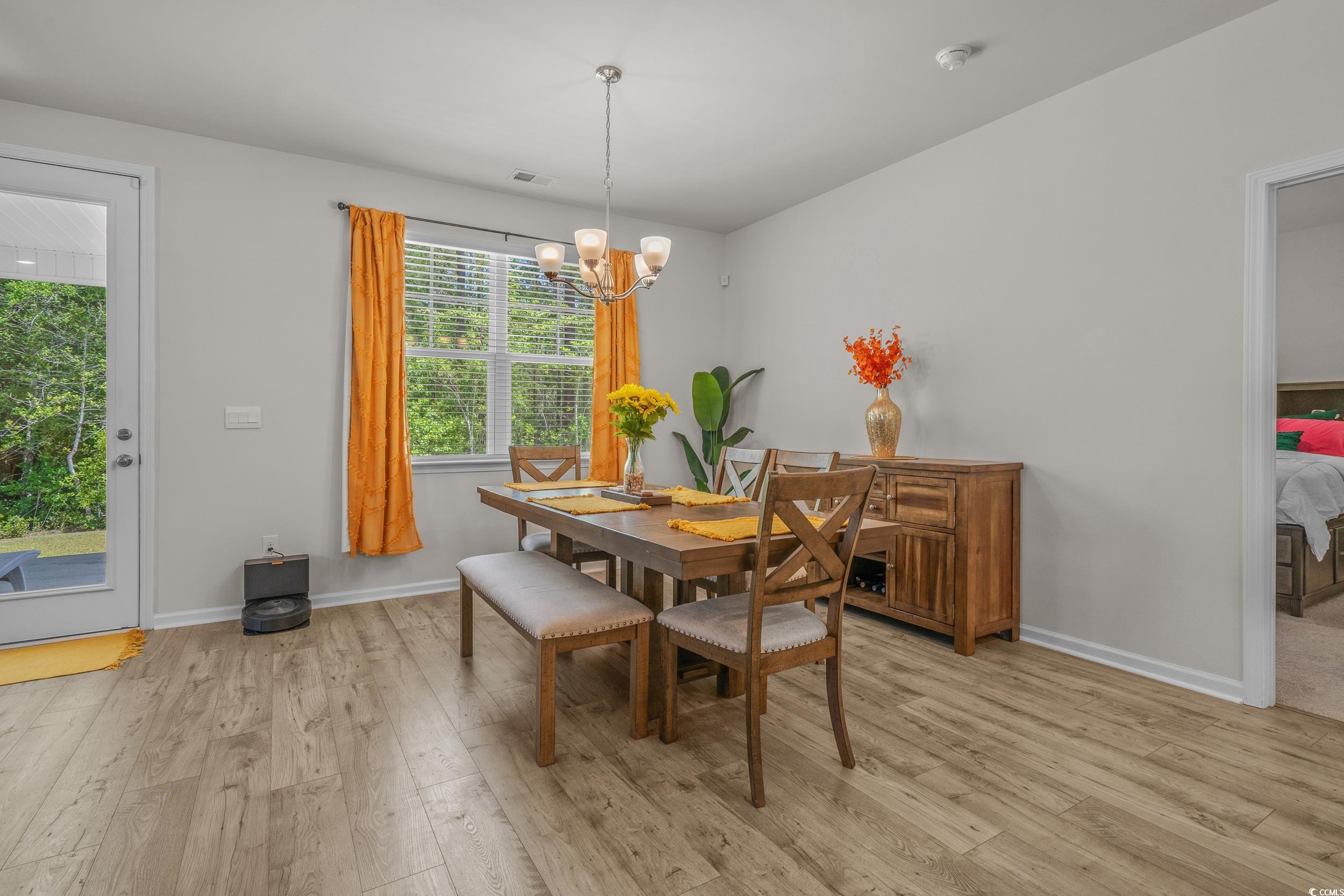 847 Flowering Br Avenue Little River, SC 29566 - Photo 7 of 30 Dining room with light wood finished floors and a chandelier