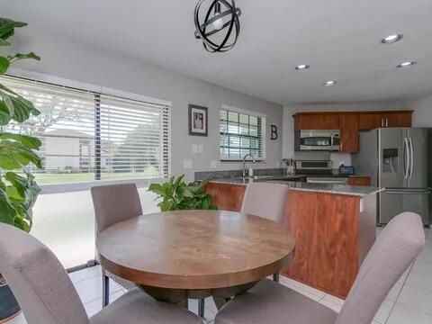 20851 Boca Ridge Drive North Boca Raton, FL 33428 - Photo 15 of 36 a living room with furniture a large window and a dining table