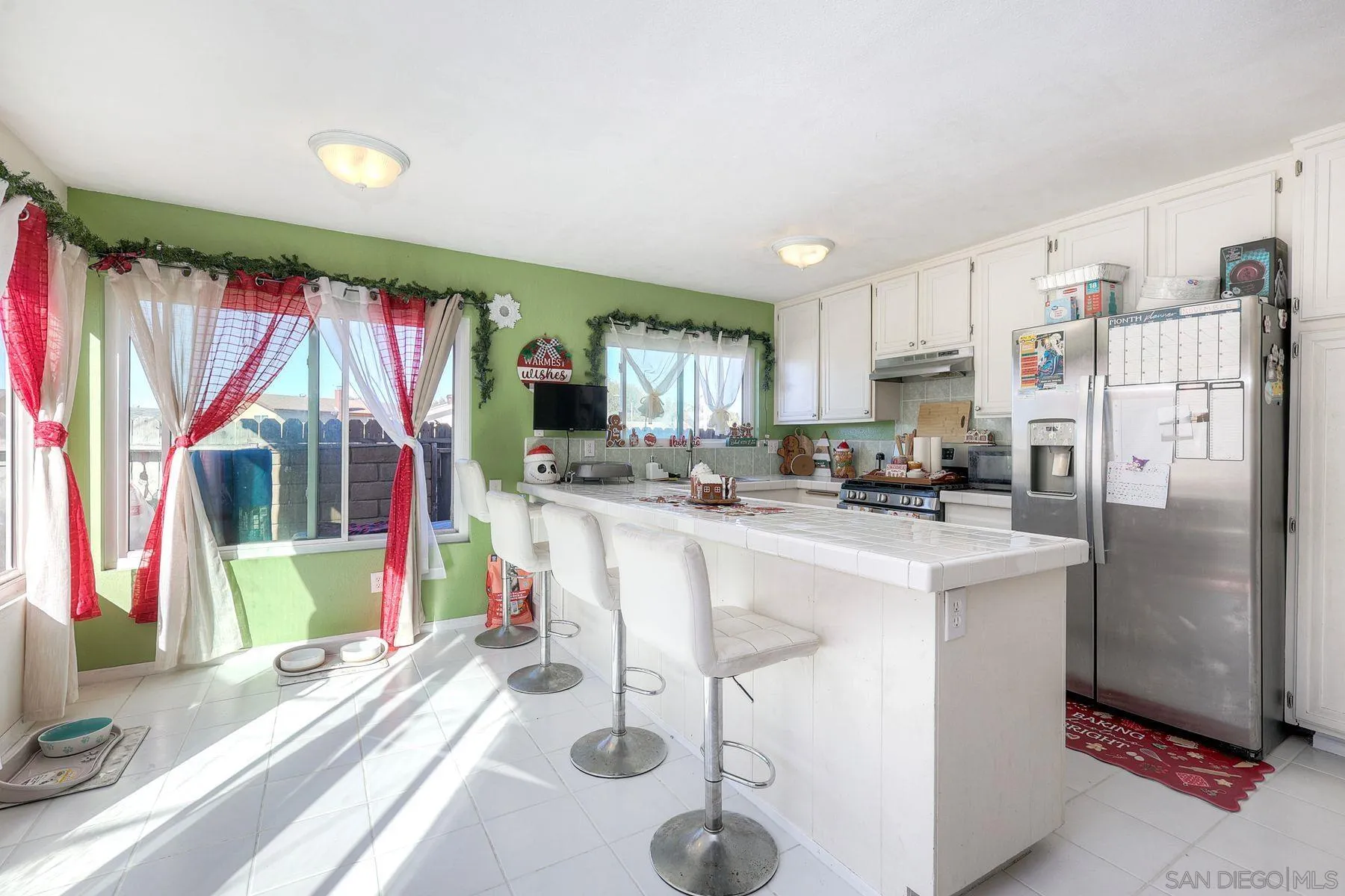 1302 Valencia Loop Chula Vista, CA 91910 - Photo 9 of 30 a kitchen with stainless steel appliances granite countertop a refrigerator a sink dishwasher a stove and a dining table with wooden floor