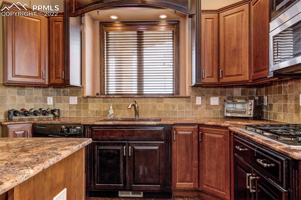 6453 Reno Road Pueblo, CO 81004 - Photo 16 of 36 a kitchen with granite countertop a stove sink and cabinets