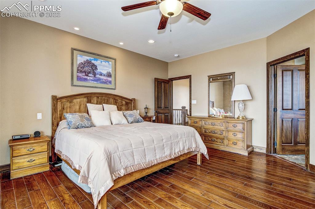 6453 Reno Road Pueblo, CO 81004 - Photo 18 of 36 a bedroom with a large bed and a chandelier