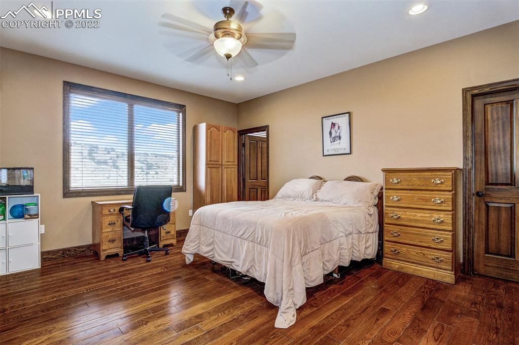 6453 Reno Road Pueblo, CO 81004 - Photo 21 of 36 a bedroom with a bed and a chandelier