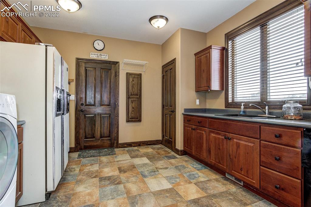 6453 Reno Road Pueblo, CO 81004 - Photo 23 of 36 a bathroom with a sink a large mirror and a refrigerator