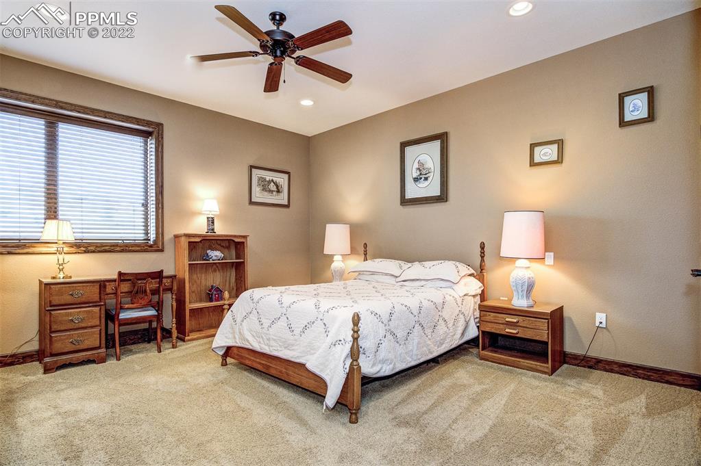 6453 Reno Road Pueblo, CO 81004 - Photo 29 of 36 a bedroom with a bed and a lamp with a bookshelf
