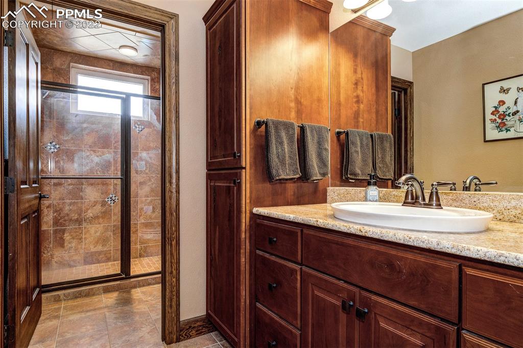 6453 Reno Road Pueblo, CO 81004 - Photo 30 of 36 a bathroom with a granite countertop sink and a mirror