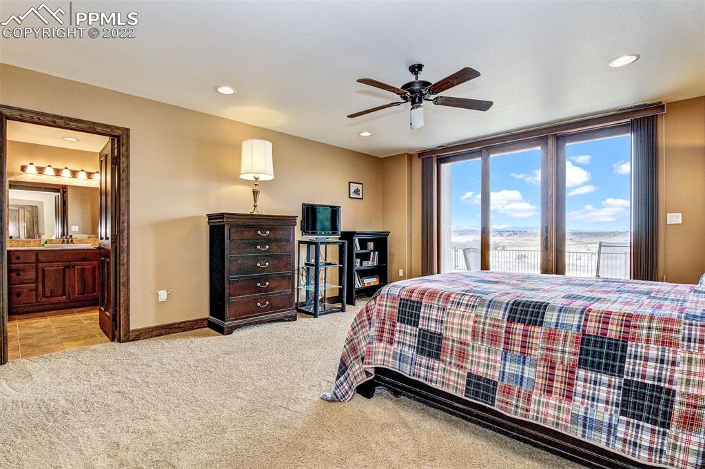 6453 Reno Road Pueblo, CO 81004 - Photo 31 of 36 a bedroom with a bed and a chandelier